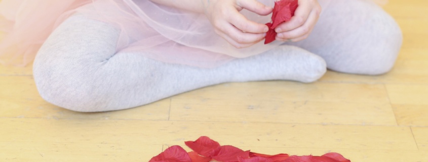 Une danseuse et des pétales de fleurs sur le parquet